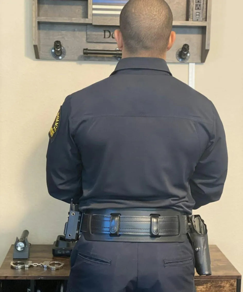 Police officer wearing smooth leather duty belt with BackUpBrace back support, rear view showing full gear loadout